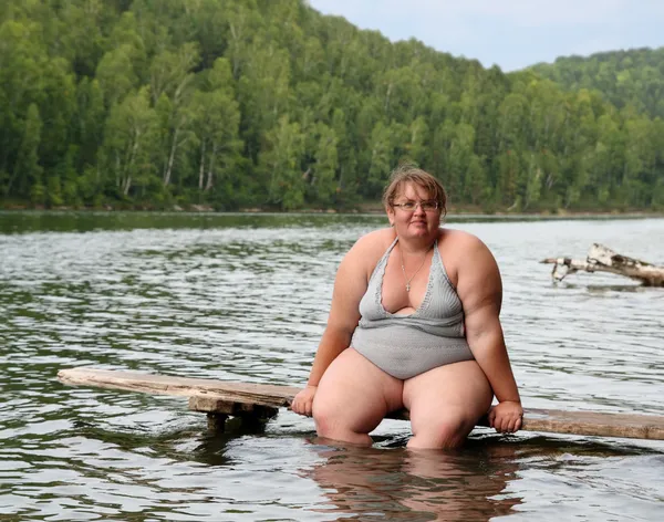 Kobieta siedzi na scenie z nadwagą — Zdjęcie stockowe