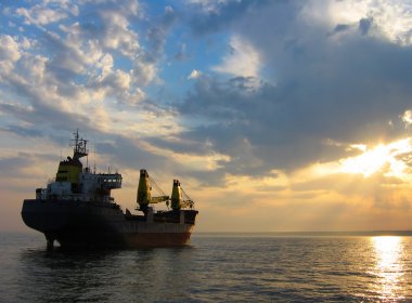 Dry cargo ship at sunset clipart