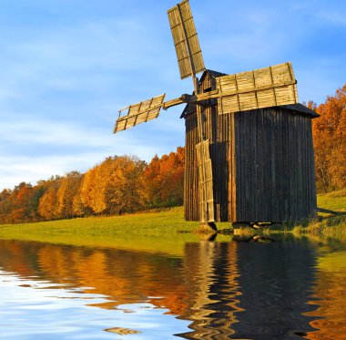 Windmill near the river clipart