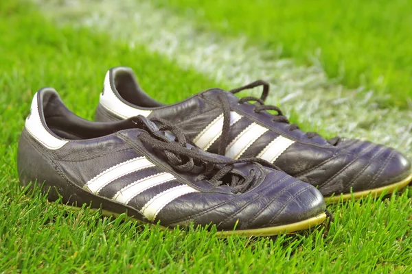 Botas de futebol em uma grama — Fotografia de Stock