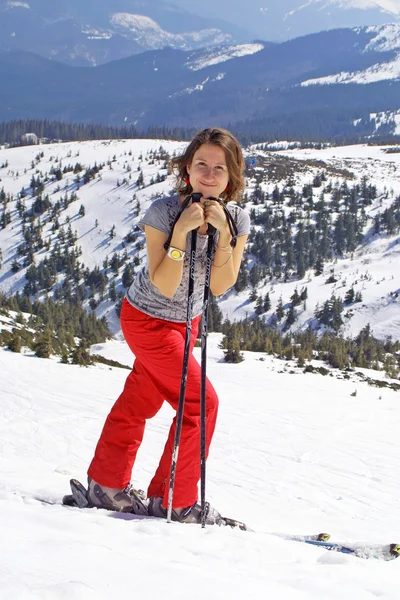 Chica con esquís que se queda en un slo de montaña — Foto de Stock