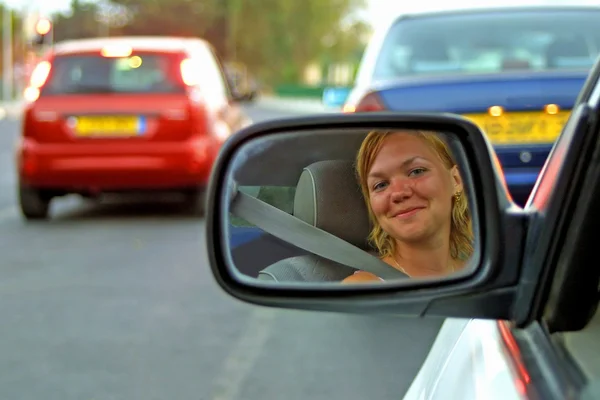 O rosto de uma jovem mulher dirigindo um carro — Fotografia de Stock