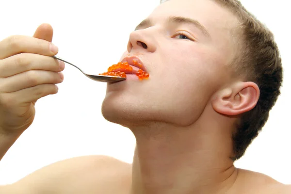 Jeune homme mangeant du caviar rouge — Photo