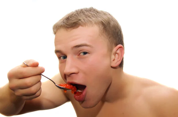 Молодий чоловік їсть червону ікру — стокове фото