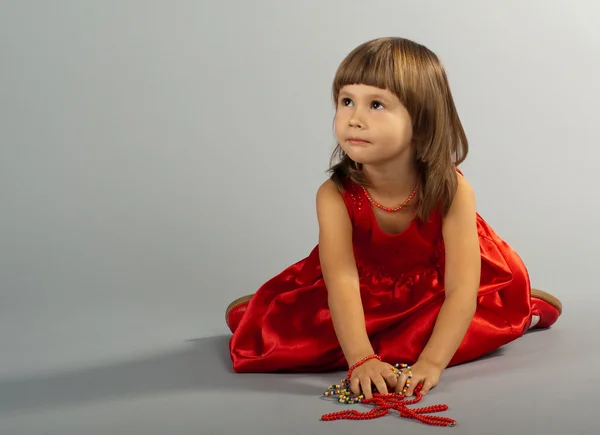 Милая маленькая девочка играет с ожерельями — стоковое фото