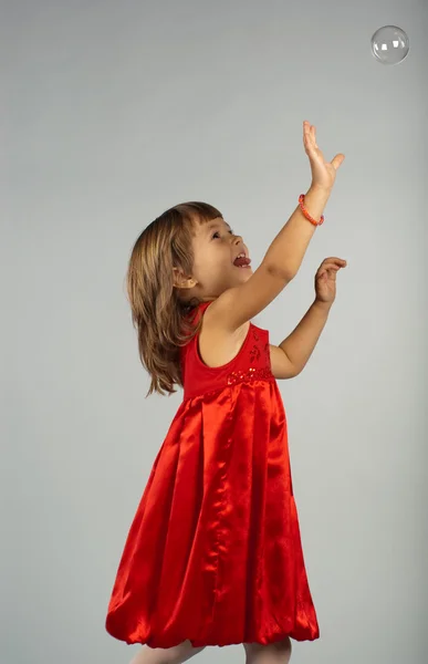 Menina bonito jogando com bolhas de sabão — Fotografia de Stock