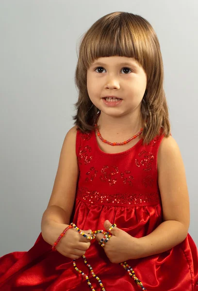 Kırmızı bir elbise, sevimli küçük kız — Stok fotoğraf