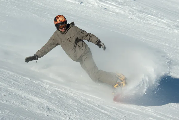 Snowboarder fährt den Hügel hinunter — Stockfoto
