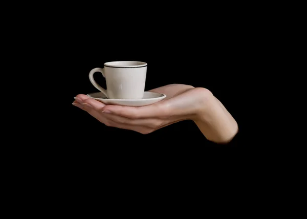 Рука держит чашку на черном фоне — стоковое фото