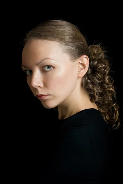 黒の背景に隠れての若い女性の肖像画 — ストック写真