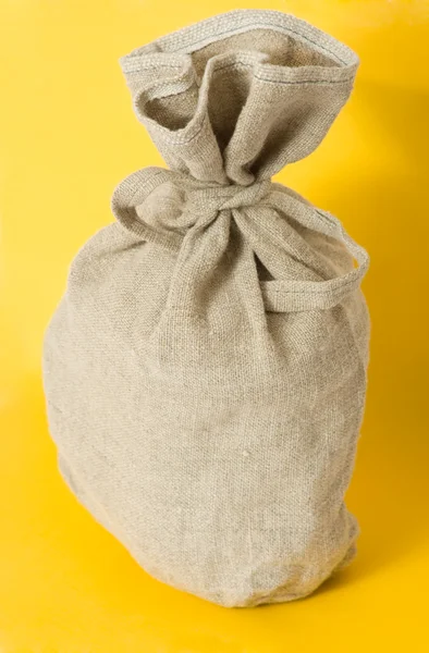 黄色の背景に茶色の織り目加工の袋 — ストック写真