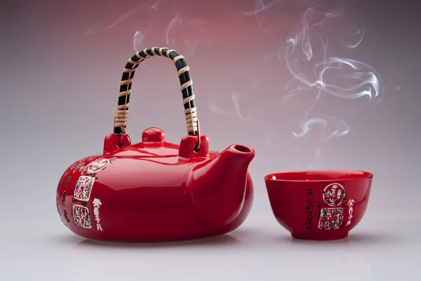 Chinese teapot with steaming cup — стокове фото