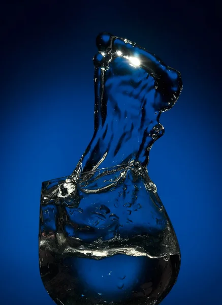 Big splash of fluid in a glass — Stock Photo, Image