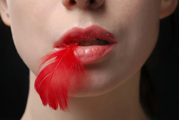 Mujer joven sosteniendo pluma roja — Foto de Stock