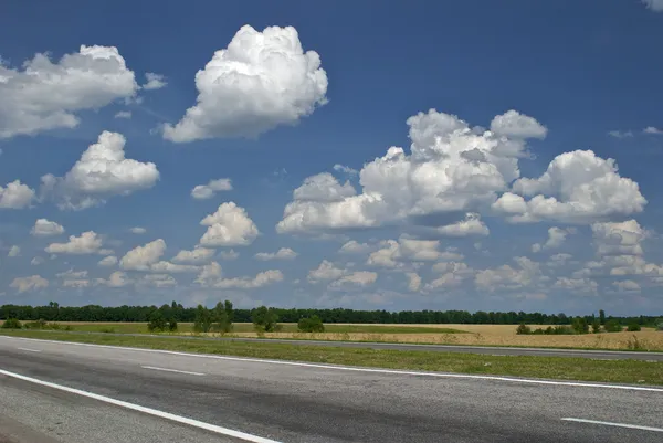 Prázdné silnici a zamračená obloha — Stock fotografie