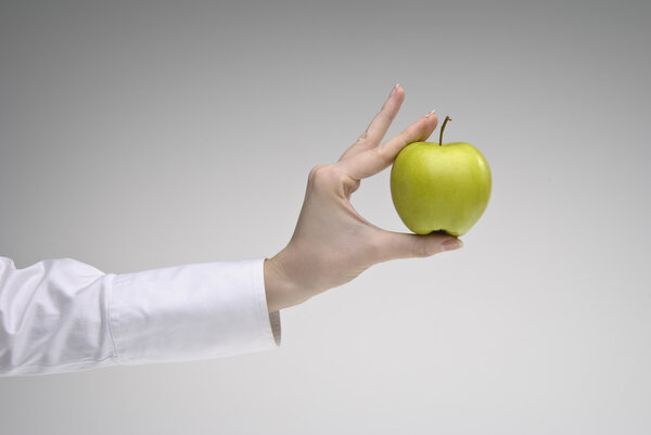 Woman's hand holding green apple