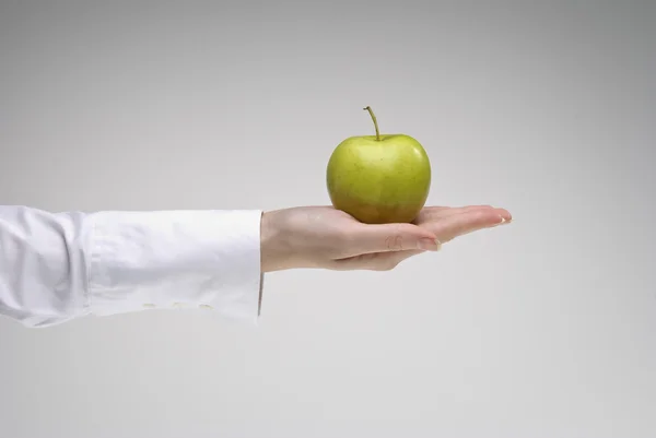 Woman's hand holding green apple — Stock Photo, Image