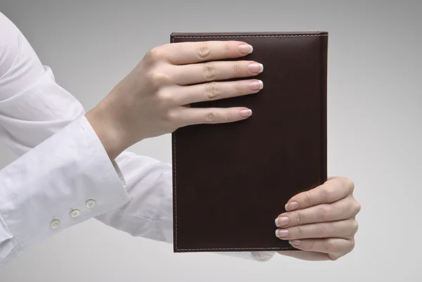 Kobiecej ręki trzymającej brązowy pamiętnik — Zdjęcie stockowe