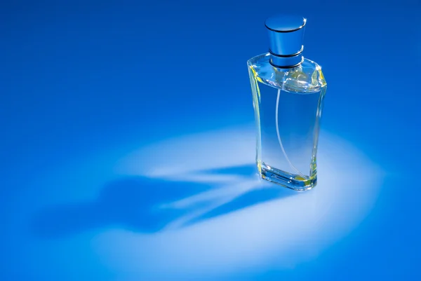 Parfum fles op blauwe achtergrond — Stockfoto