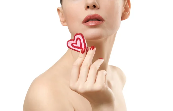 Молодая женщина показывает конфеты в форме сердца . — стоковое фото