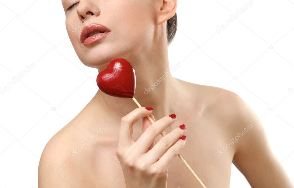 Young woman showing heart shaped candy.