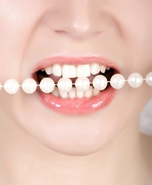Teeth biting on faux pearls clipart