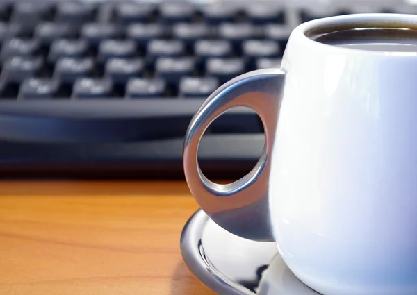 Xícara de café e teclado preto — Fotografia de Stock