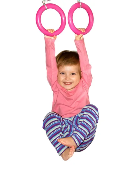 Cute girl hangs from rings — Stock Photo, Image