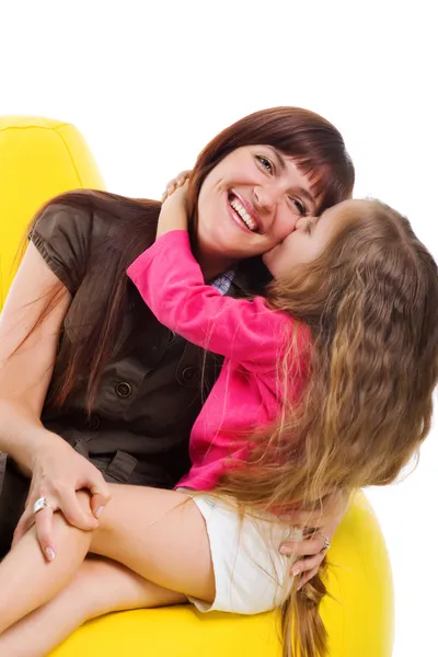 Süßes kleines Mädchen küsst ihre Smiley-Mutter — Stockfoto
