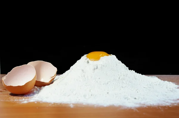 Мука, яйцо и скорлупа на столе — стоковое фото