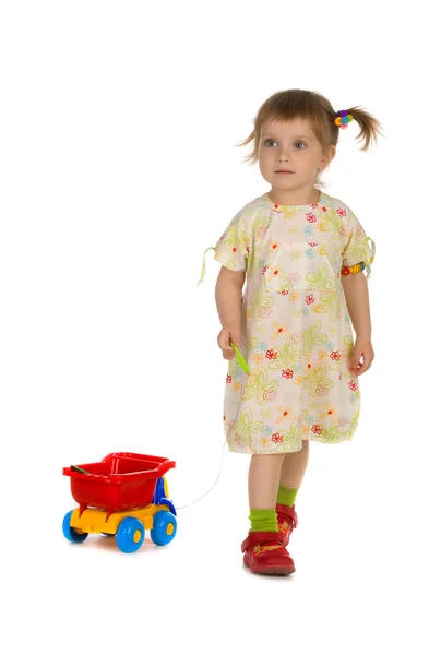 Klein meisje draagt de speelgoedauto — Stockfoto