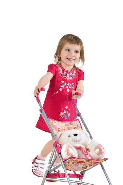 Little girl with toy carriage — Stock Photo, Image