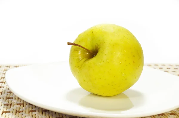 Jabłko na białym talerzu — Zdjęcie stockowe