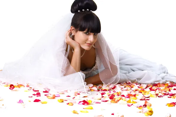 Krásná nevěsta s okvětními lístky růží — Stock fotografie