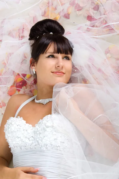 Прекрасная невеста с лепестками роз — стоковое фото