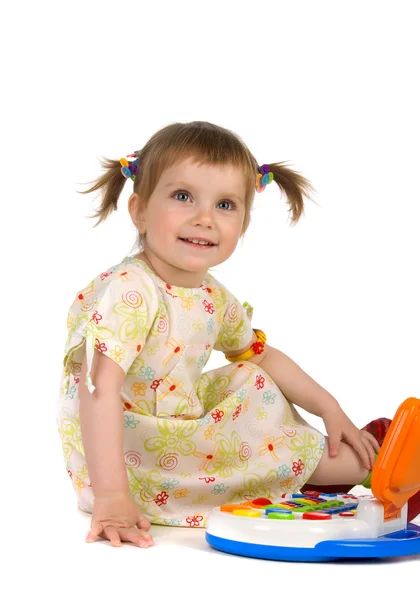 Roztomilá malá holka a hračky laptop — Stock fotografie