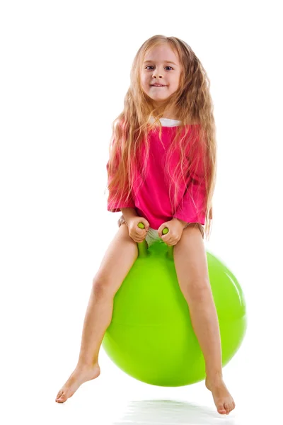Bambina saltare su una grande palla verde — Foto Stock