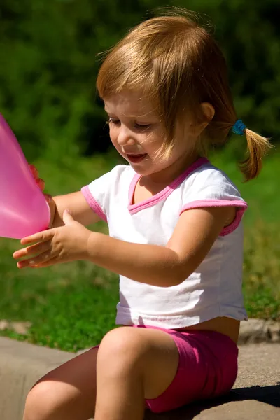 Liten flicka med en rosa ballong — Stockfoto