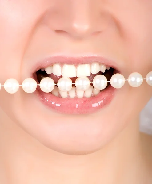 Teeth biting on faux pearls — Stock Photo, Image
