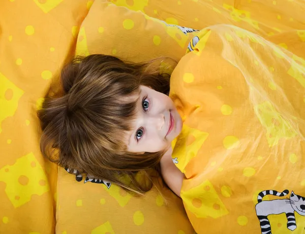 Schattig klein meisje op het bed — Stockfoto