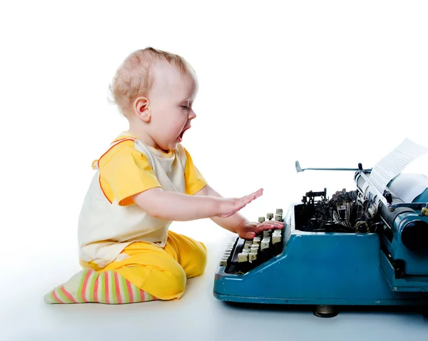 Маленький хлопчик зі старою друкарською машинкою — стокове фото