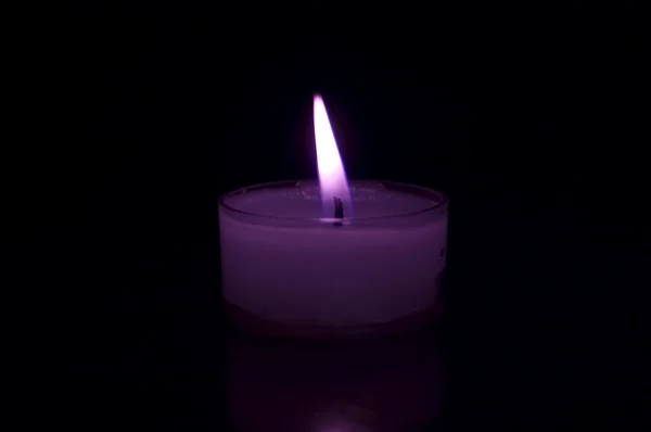 Purple candle in darkness — Stock Photo, Image