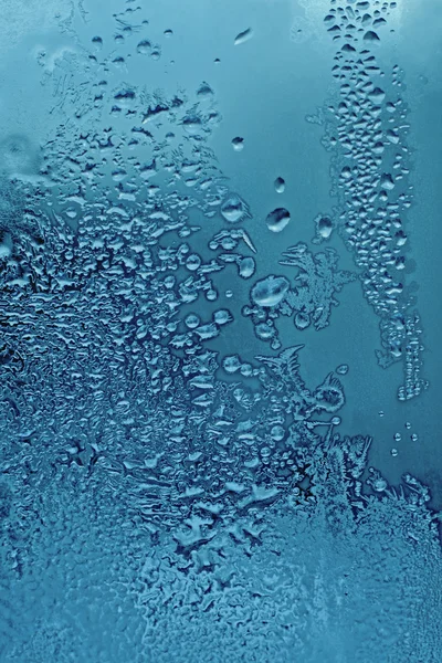Waterdruppels en vorst op glas — Stockfoto