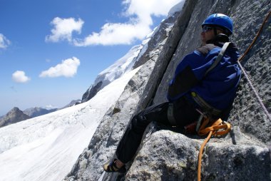 Mountaineer sits on a rock clipart