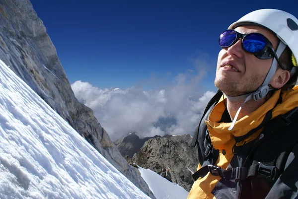 Rock-escalador examina maneira no topo — Fotografia de Stock