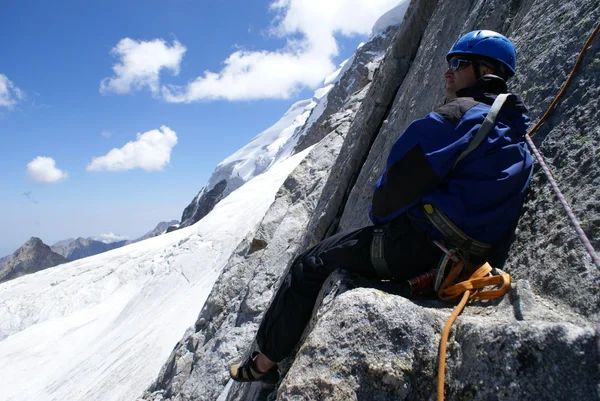 Mountaineer senta-se em uma rocha — Fotografia de Stock