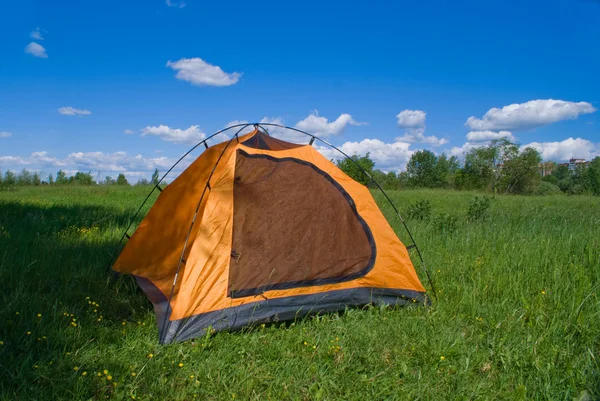 Туристическая желтая палатка на зеленой лужайке — стоковое фото