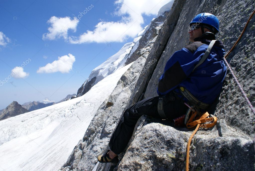 Mountaineer sits on a rock