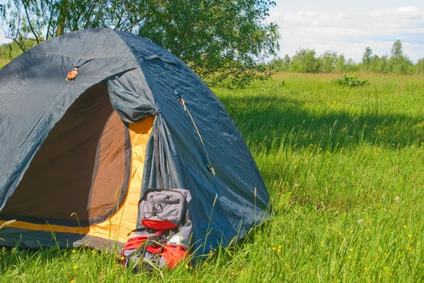 Зеленая туристическая палатка и рюкзак — стоковое фото