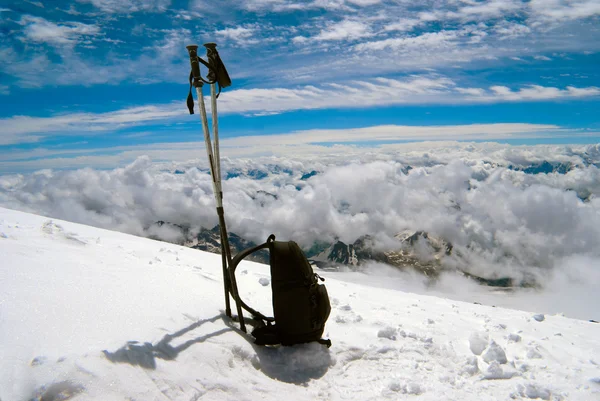 Bastones de esquí y mochila cuestan a la nieve — Foto de Stock